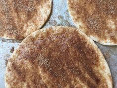 four flat breads on a baking sheet with sugar sprinkled on them, ready to go into the oven