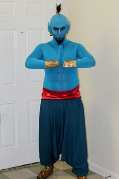 a man dressed in blue and gold with his hands on his hips