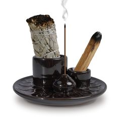 a candle holder with two sticks sticking out of it's top, on a saucer