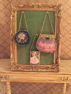 two purses are hanging on a gold frame