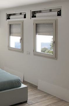 a bedroom with two windows and a bed