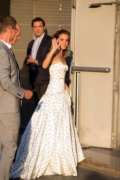 a woman in a white dress walking down the street