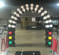 an arch made out of black, white and red balloons in the middle of a room