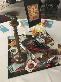 a table topped with pictures and a candle on top of a white cloth covered table