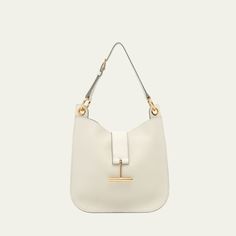 TOM FORD "Tara" crossbody bag in grain leather, faux leather (polyurethane), and brass  Detachable, adjustable shoulder strap Detachable, adjustable crossbody strap Can be worn as a shoulder or crossbody bag  Open top with center T-strap magnetic closure  Interior, one zip pocket  Lining: Polyurethane Approx. 9.8"H x 9.8"W x 0.8"D Item Weight (Lbs.): 1.5 Made in Italy Open Top, T Strap, Crossbody Strap, Magnetic Closure, Tom Ford, Cross Body Handbags, Zip Pockets, Crossbody Bag, Grain