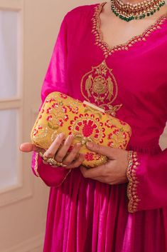 "Our Alanna clutch is detailed with thread and zari and sequin embroidery on soft silk. Pair this with a vibrant pink ensemble and watch it stand out as a statement accessory! Embroidered front and back. Dimensions (LxB): 8\"x4\" (20.3 cm X 10.1 cm) Handle length: 47\" (120 cm) Handle drop: 23\" (58 cm) Material: Embroidery pure silk, suede lining, fabric encased metal clutch frame, golden metal sling. Features: Fabric encased metal frame, gold metal lock closure, gold detachable metal sling." Golden Clutch, Colourful Embroidery, Unique Clutch, Silk Bag, Sequin Embroidery, Functional Fashion, Indian Textiles, Box Clutch, Sequins Embroidery