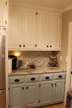 a kitchen with white cabinets and granite counter tops