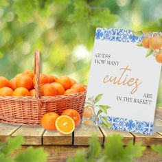 a basket full of oranges sitting next to a sign that says guess how many cuties are in the basket