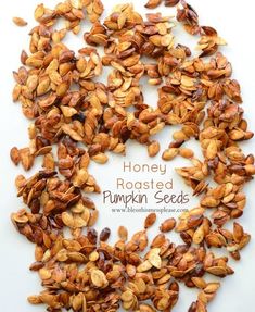 roasted pumpkin seeds on a white surface with the words honey roasted pumpkin seeds in the middle