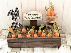 some carrots are in a wooden box with a sign