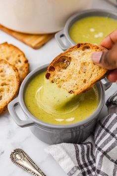 a person dipping some bread into a bowl of soup