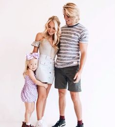 a man, woman and child posing for a photo in front of a white background