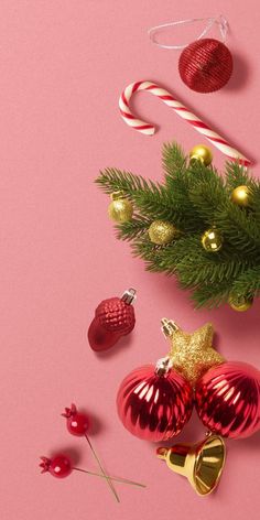 christmas decorations and candy canes on a pink background