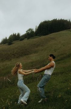 a man and woman are dancing in the grass