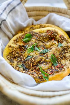 a bread with herbs and seasoning in a basket