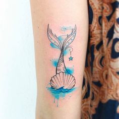 a mermaid tail tattoo on the arm