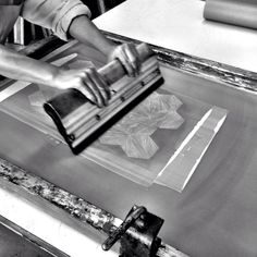 a person using a machine to cut paper