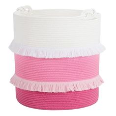 a pink and white basket with fringes on the bottom, sitting against a white background