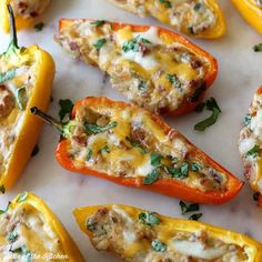 several stuffed peppers with cheese and herbs on them