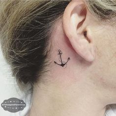 a small anchor tattoo behind the ear