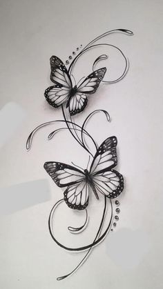 two butterflies with swirls and dots on white paper