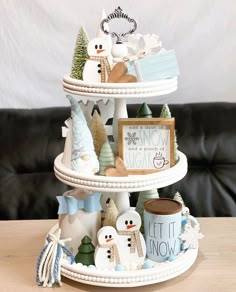 a three tiered cake stand with snowmen on it