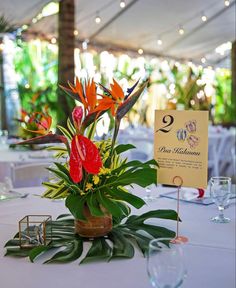 an arrangement of flowers on a table at a wedding reception in a marquee