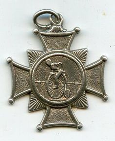 an antique silver cross with a bicycle on it's center and a medal hanging from the side