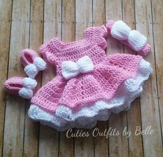 a pink and white crochet dress with matching shoes is laying on the floor