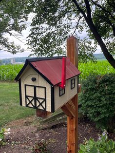 a bird house with a red roof on a wooden post