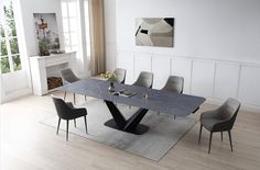 a dining room table with chairs and a rug on the floor in front of it