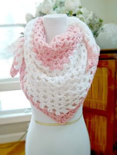 a white and pink crocheted scarf on a mannequin