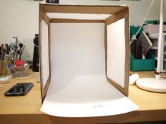 an open box sitting on top of a desk next to a cell phone and other items