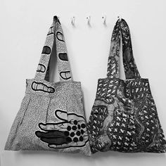 two purses are hanging on the wall, one has a black and white design