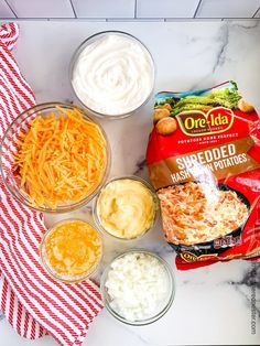 ingredients to make cheese dip laid out on a marble counter with red and white napkins