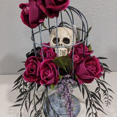 a skull in a birdcage with purple flowers