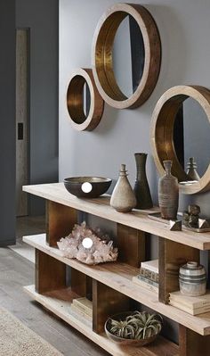 a living room filled with lots of furniture and mirrors on the wall above it's shelves