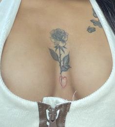 a close up of a woman with tattoos on her chest and breast, wearing a white shirt