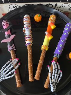 halloween treats made to look like skeleton hands and bones on a black plate with candy