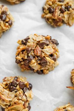 chocolate chip cookies with granola and nuts arranged on top of parchment paper, ready to be eaten