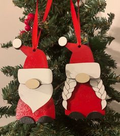 two red and white ornaments hanging from a christmas tree