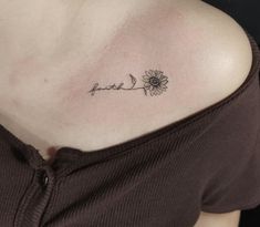 a sunflower tattoo on the back of a woman's shoulder