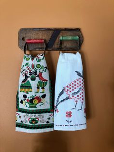 two kitchen towels hanging on a wooden rack