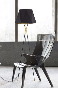 a chair with a lamp next to it on the floor in front of a window