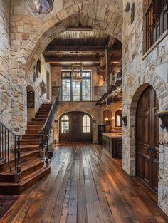 an open floor plan with stone walls and wood floors, arched doorways, and stairs