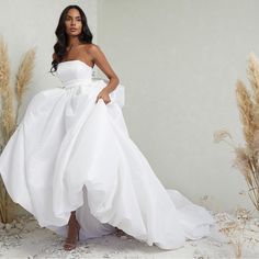 a woman in a white wedding dress posing for the camera