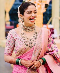 a woman in a pink sari smiling