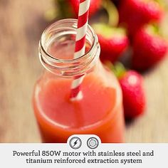 a glass jar filled with liquid next to strawberries