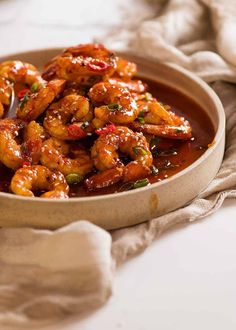 a bowl filled with shrimp and sauce on top of a table