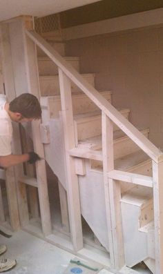 a man working on some stairs in a house